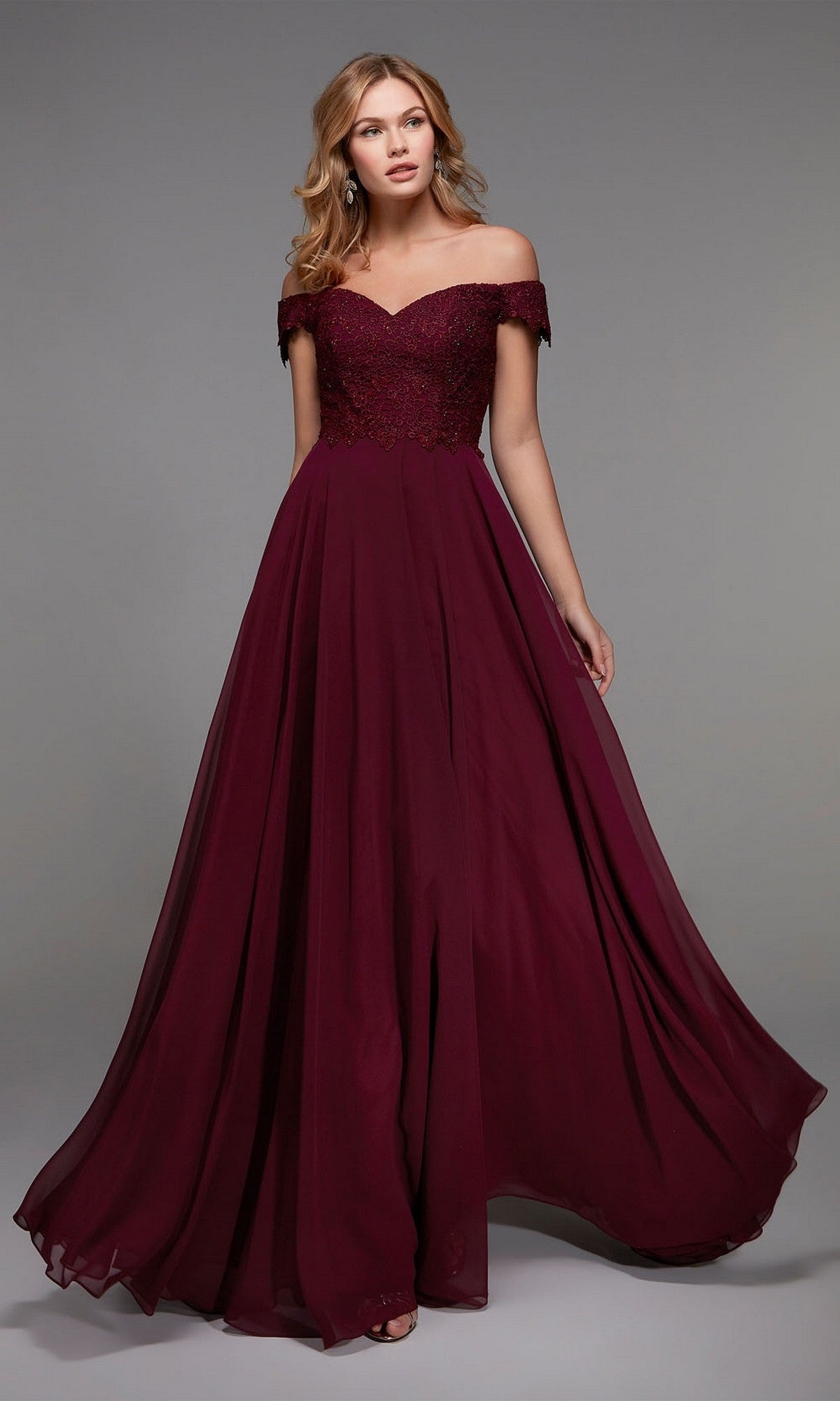 A woman models the Alyce 27510 long formal dress in Black Cherry, featuring an off-the-shoulder lace bodice and flowing skirt, standing against a plain gray background for an elegant mother-of-the-bride look.
